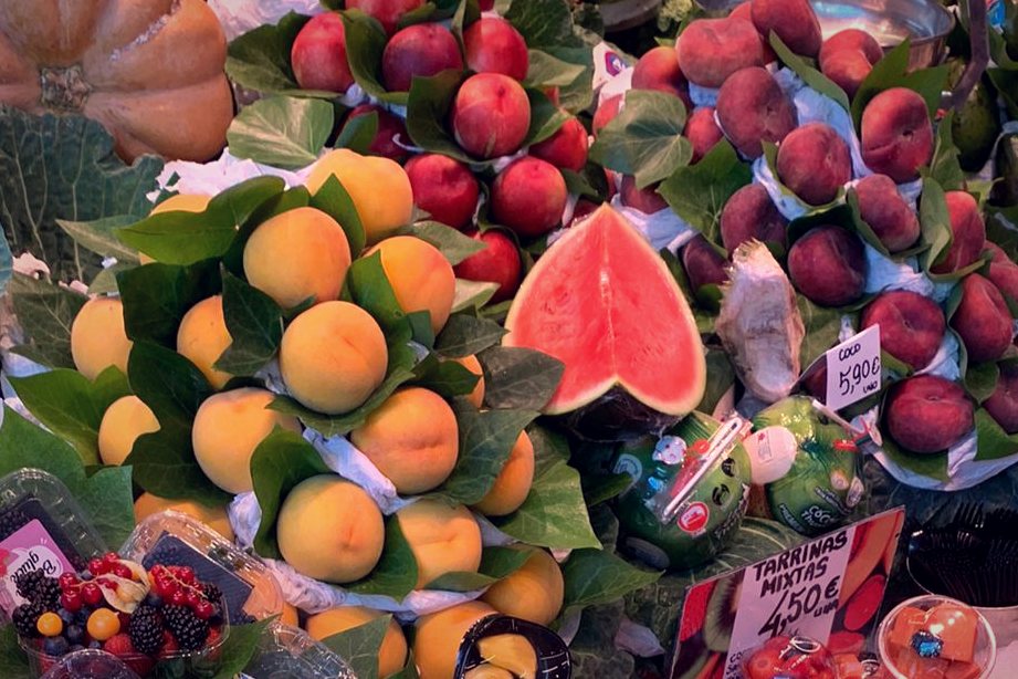 Peaches, plums and a watermelon slice at a market